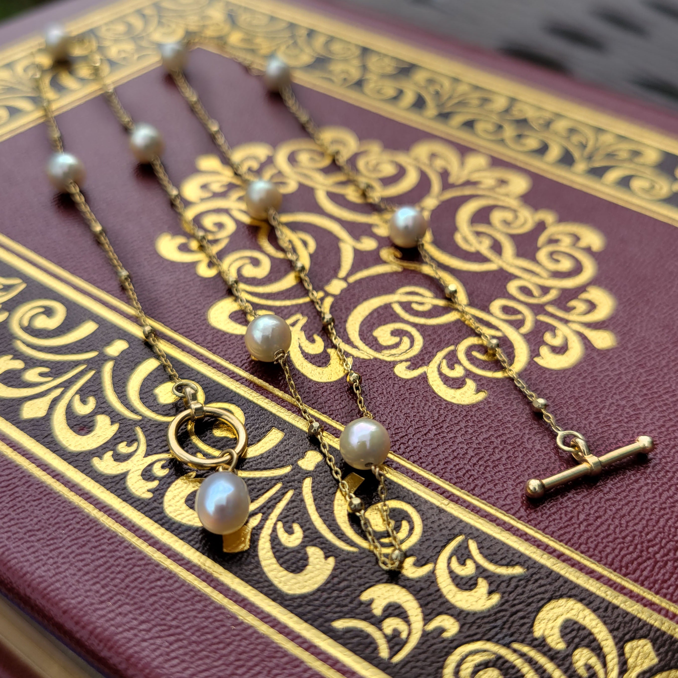 pearl and gold necklace on vintage book