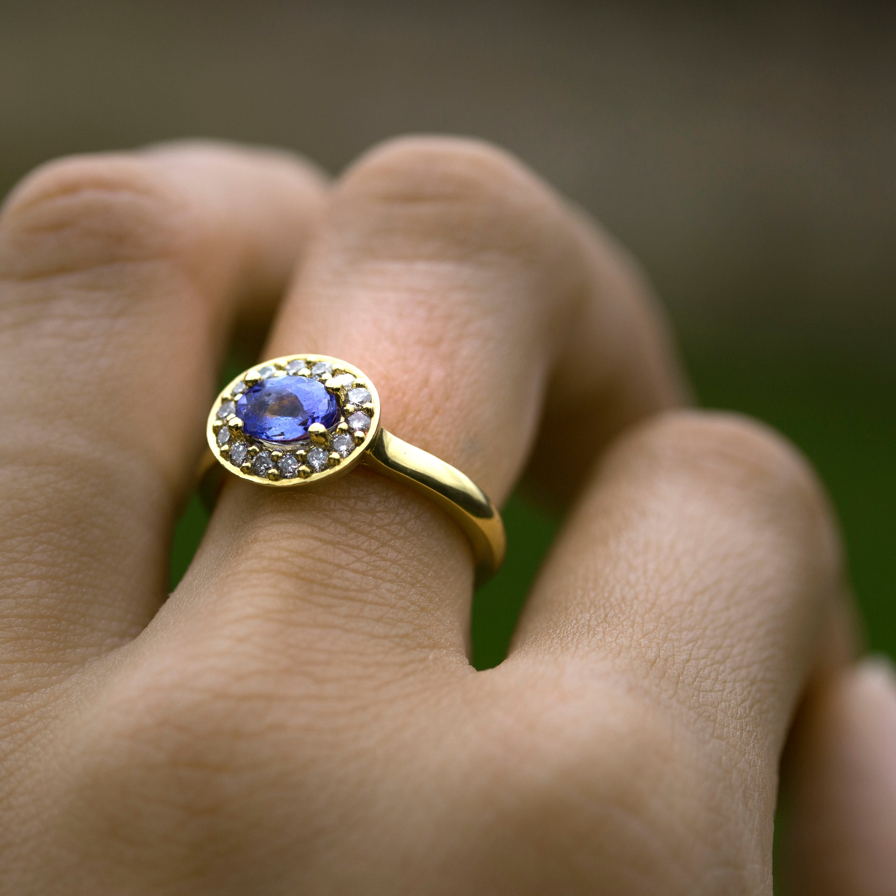 oval tanzanite with diamond halo in yellow gold