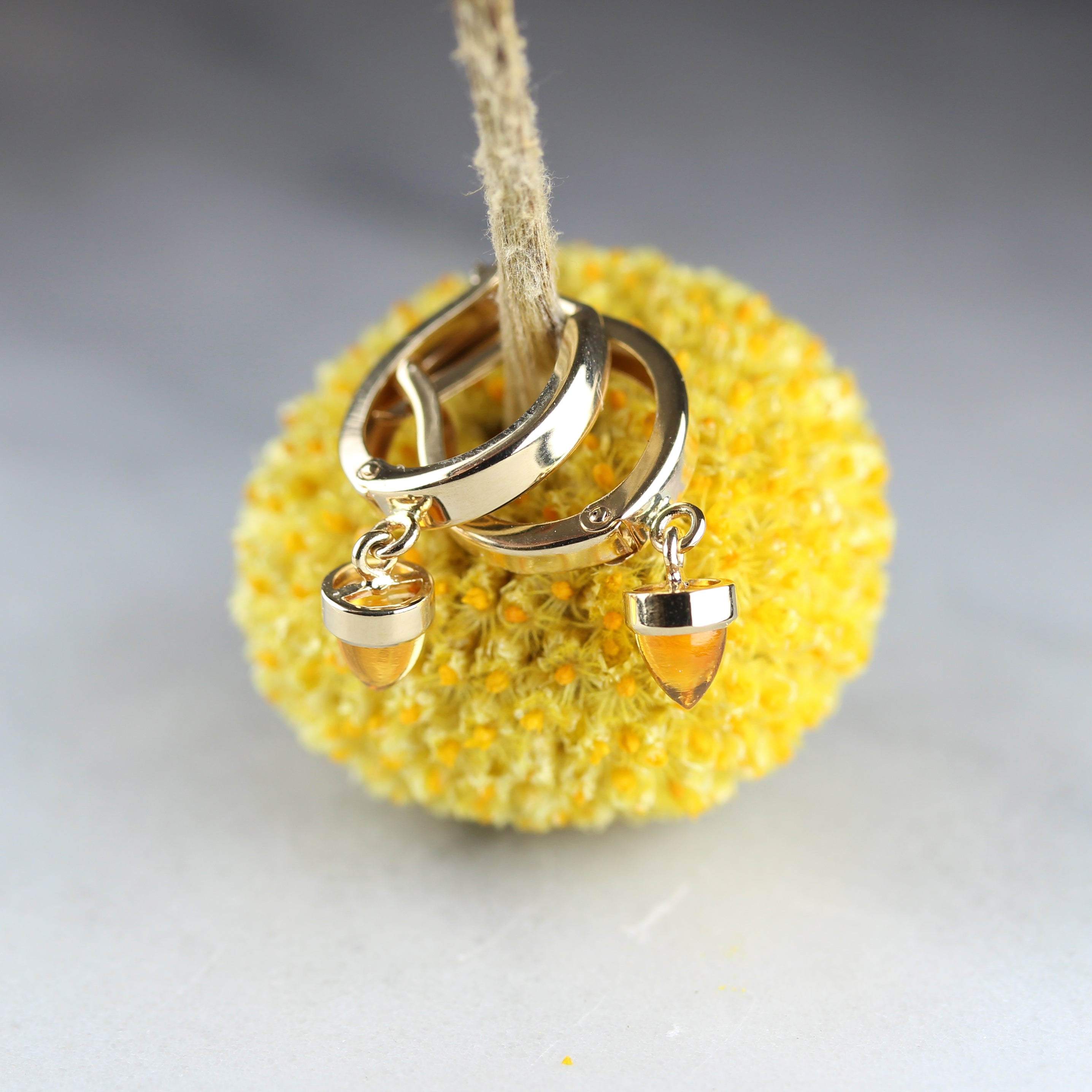 citrine bullet and yellow gold earrings on yellow flower