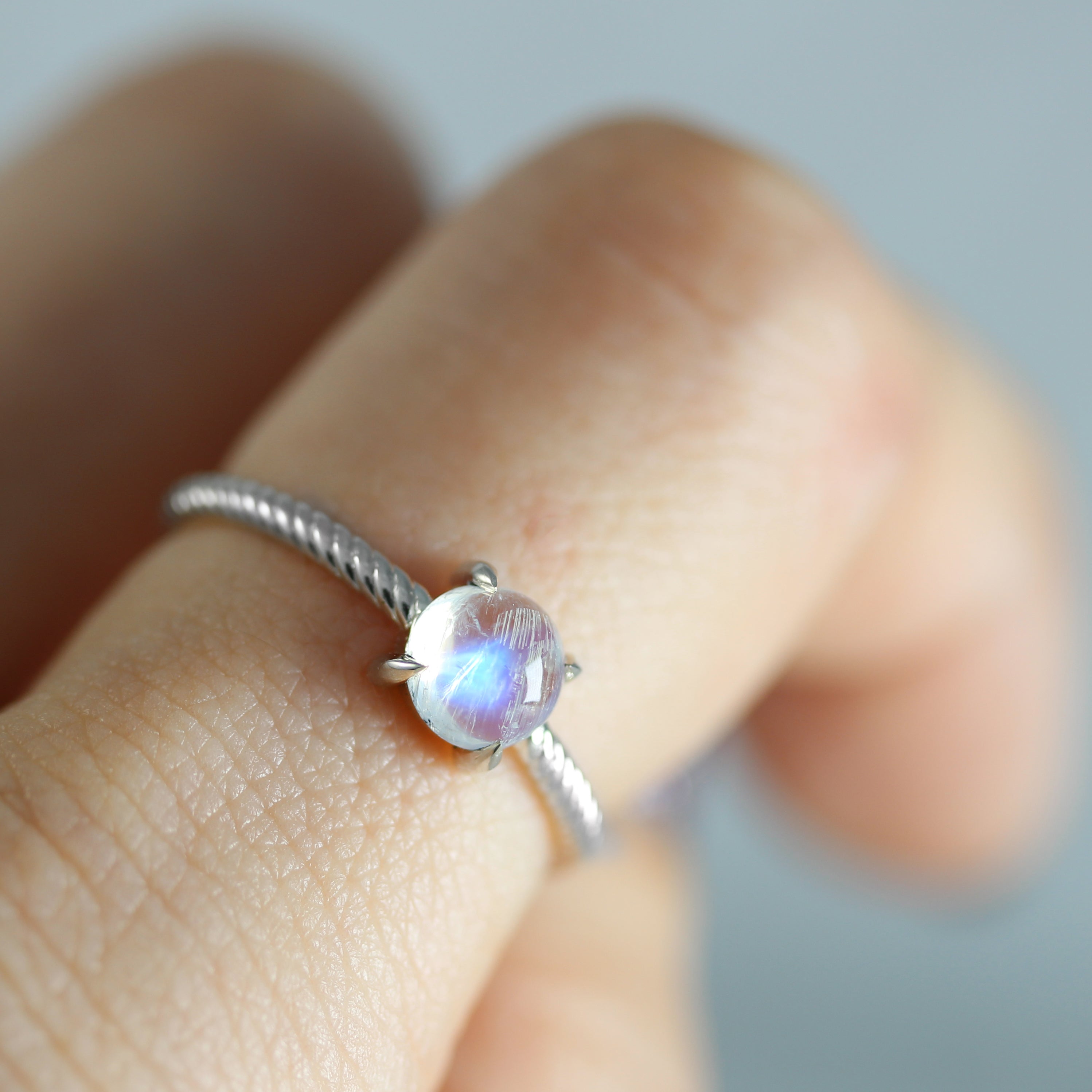 moonstone in silver rope ring on finger