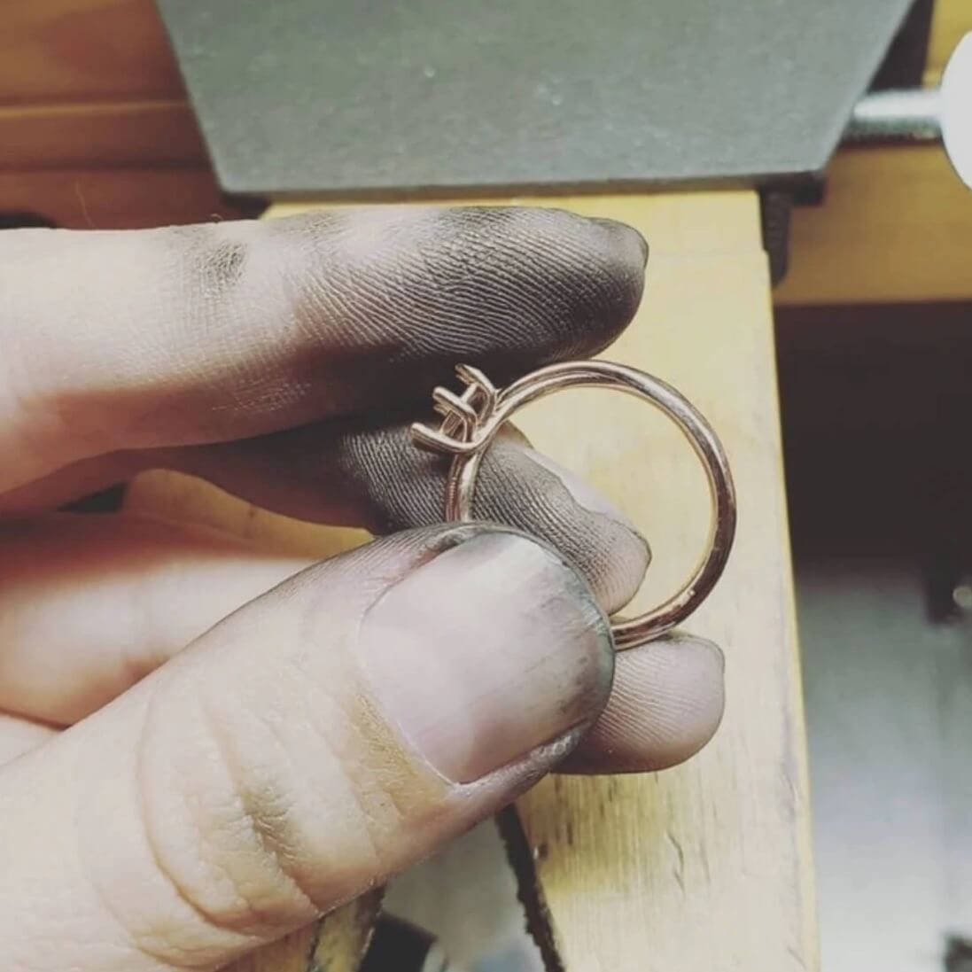 rose gold engagement ring being worked on jewelry bench
