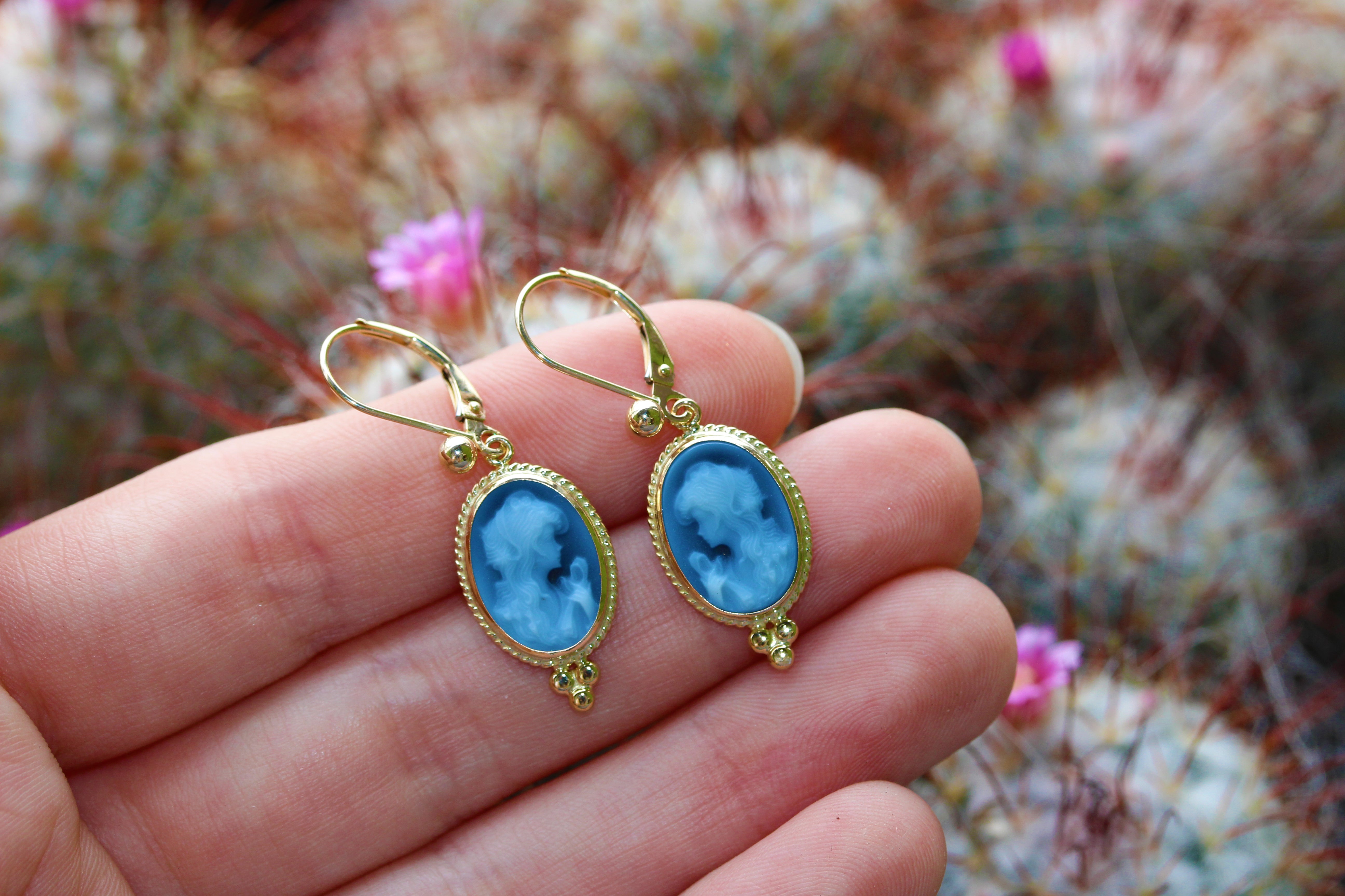 cameo earrings on hands with cactus background