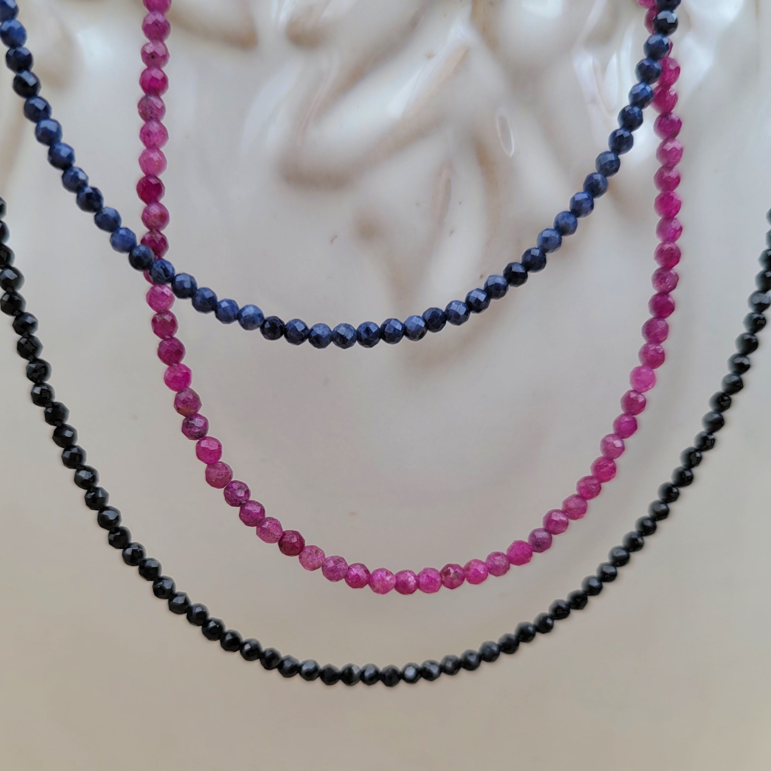 faceted gemstone beaded necklaces on white pot