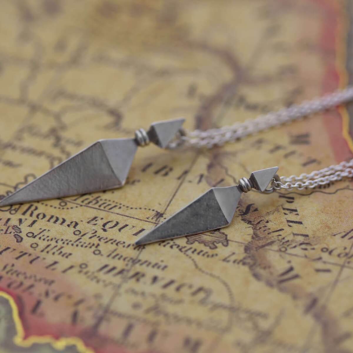 Large and Small Silver Pyramid Spike Pendants on Silver Chains on Antique Map